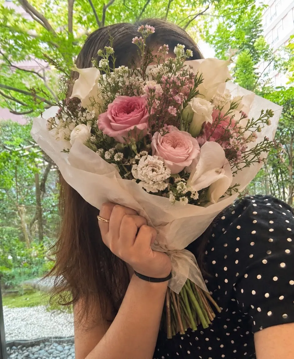 Andrea, fundadora de Roses for Rosie, con un ramo de rosas y alcatraces